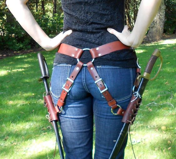 Dual Sword Belt (SM). $, via Etsy. The ring at the back allows the weight of the swords to distribute evenly across the bearer's hips, and the angled frogs make drawing the swords much easier.