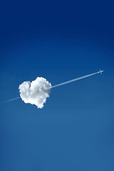 Heart shaped cloud with plane