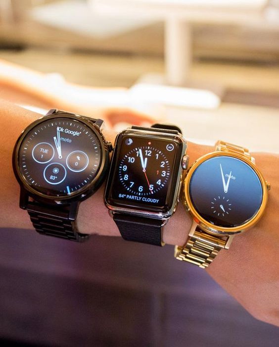 The Motorola Moto 360 compared to the Apple Watch (in the middle)