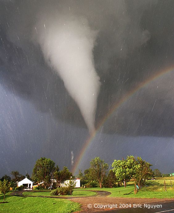 The scene might have been considered serene if it weren't for the tornado. During 2004 in Kansas, storm chaser Eric Nguyen photographed this budding twister in a different light -- the light of a rainbow. Pictured above, a white tornado cloud descends from a dark storm cloud. The Sun, peeking through a clear patch of sky to the left, illuminates some buildings in the foreground. Sunlight reflects off raindrops to form a rainbow. By coincidence, the tornado appears to end right over the rainbow.