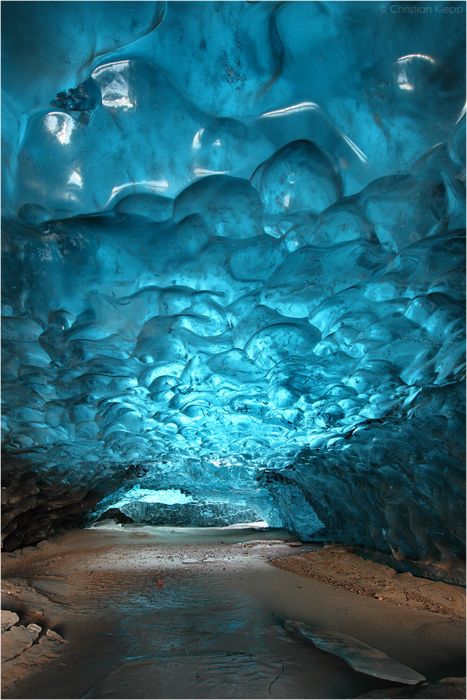 This up to 1000 years old snow has metamorphosed into highly pressurized glacier ice that contains almost no air bubbles. Thus it absorbs the visible light despite the scattered shortest blue fraction, giving it its distinct deep blue waved appearance. This cavity in the glacier ice formed as a result of a glacial mill, or moulin. / Svínafellsjökull glacier in Skaftafell, Iceland