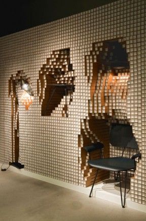 A modular wall made from 10,000 paper pipes that encapsulates furniture