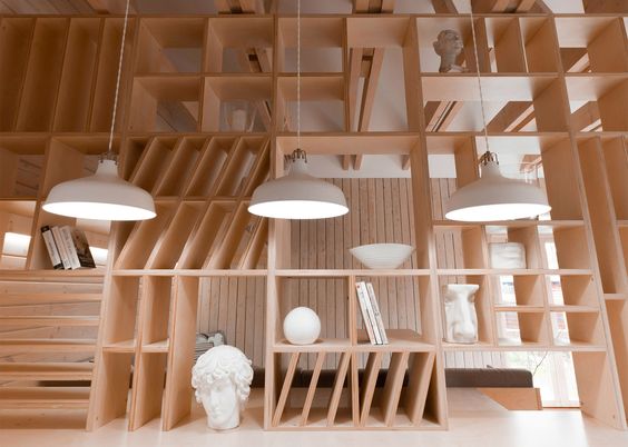 A plywood partition separates working and relaxation areas inside this Moscow studio and incorporates furniture and shelves for art supplies.
