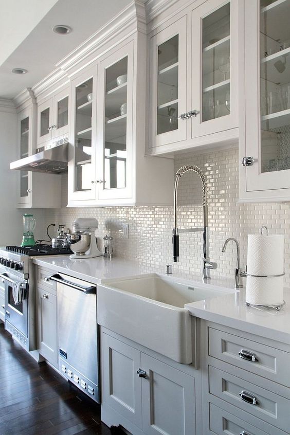 Beautiful white kitchen with farmhouse sink and white cabinets some with glass fronts.