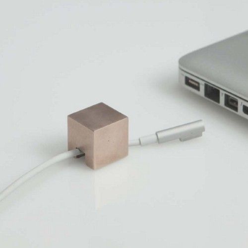 Bronze Cable Holder is a minimalist design created by RISD student Kebei Li. These little casted bronze cubes are designed to prevent cables from falling from your tabletop.