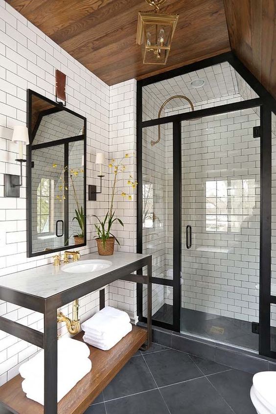 Contemporary bathroom with ironwork, glass door walk-in shower, and modern touches of brass lighting and hardware.