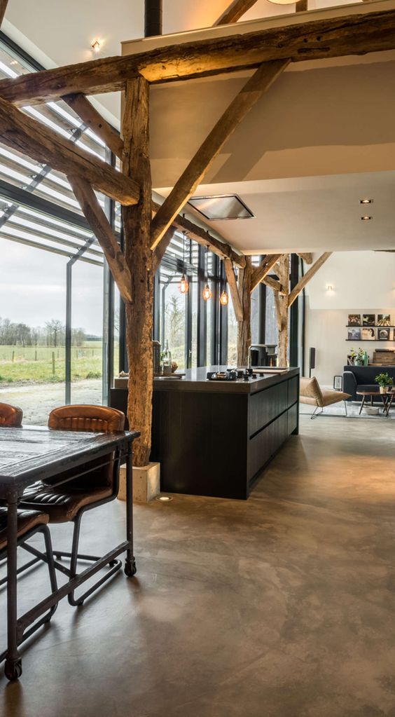 Converting an old farm into a warm industrial farmhouse with big view on an old brick wall, original wooden beams and the beautiful area around the farmhouse.