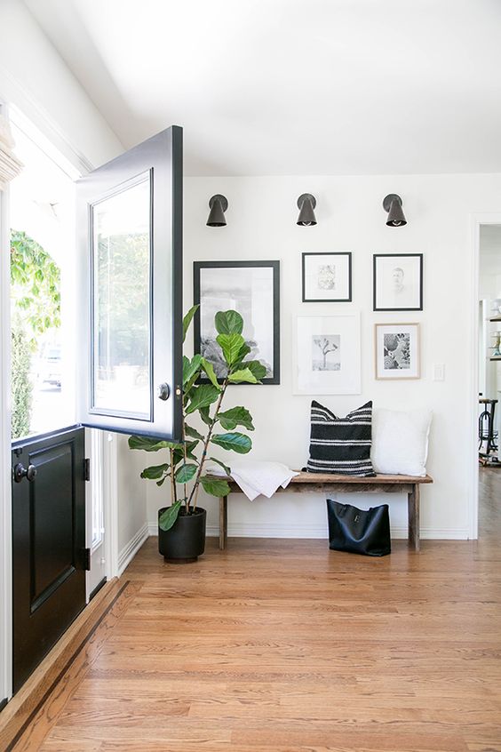 Entryway with a wood bench and black and white gallery wall
