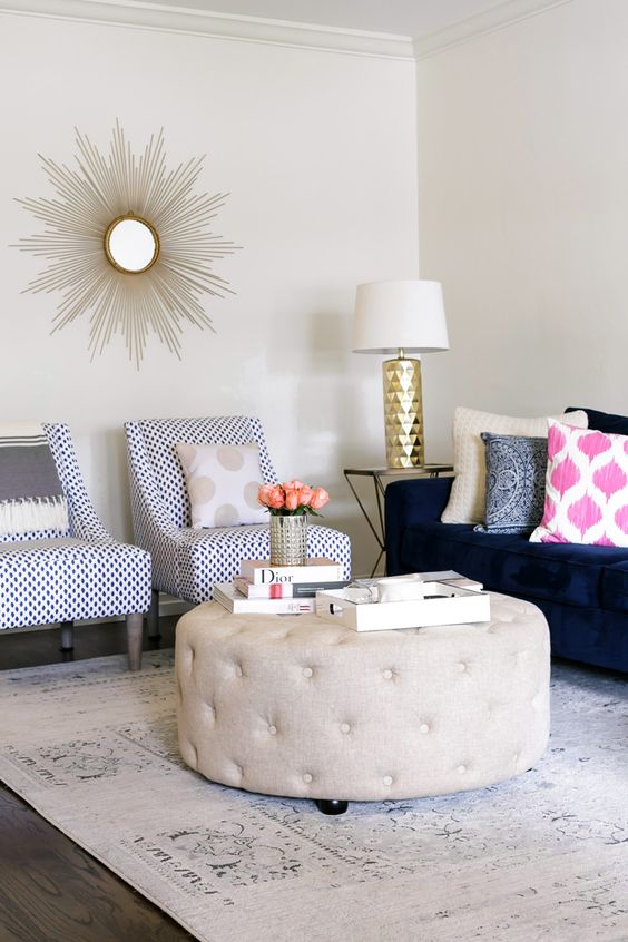 gold spike mirror in living room. love the tufted ottoman