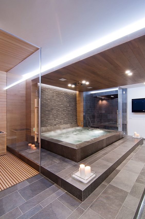Huge jacuzzi in the master bathroom surrounded by stone tile and wood ceiling, spa like bathroom | STIMAMIGLIO conceptluxurydesign