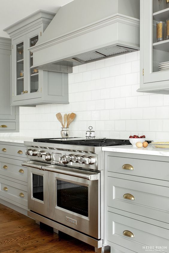 Kitchen with Light Gray Cabinets and Covered Range Hood - Heidi Piron Design