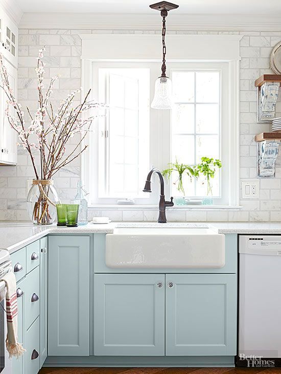 Light blue painted lower cabinets and a farmhouse apron sink make for pretty, French country-inspired kitchen style!