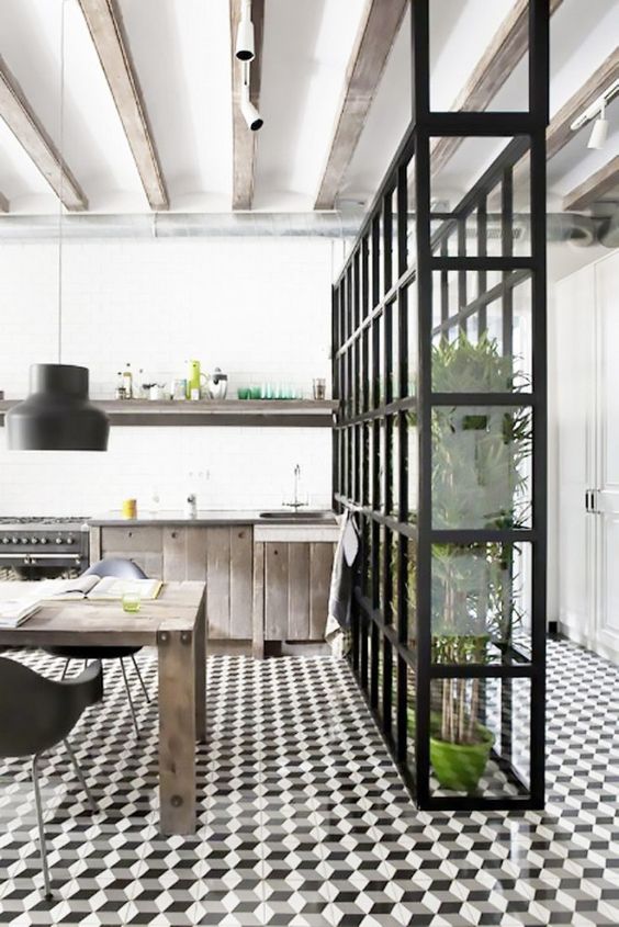 Minimalist kitchen with exposed ceiling beams, graphic tiles floors, and a wall of greenery
