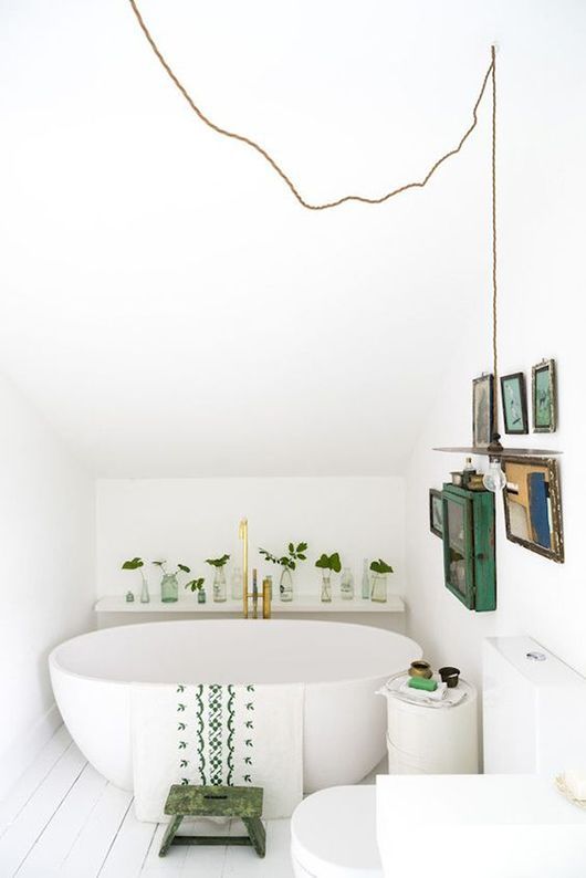 modern white bathroom with pops of green plants and art