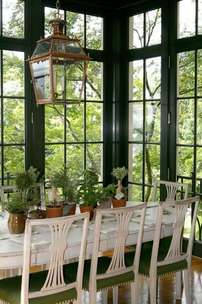 painted chairs, wall of windows, lantern fixture.