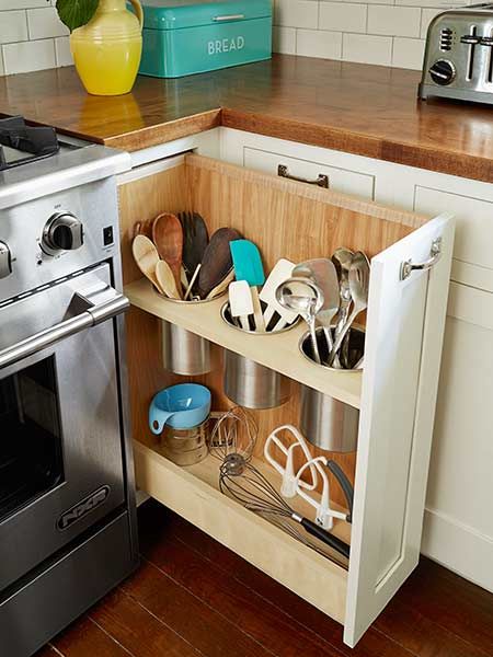 pullout shelf in kitchen cabinets with storage room for cooking utensils like spatulas