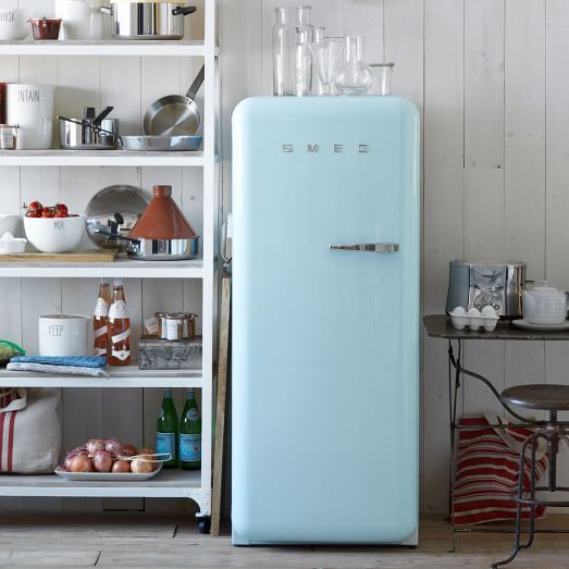 SMEG, Refrigerator, Pastel Green in a perfect kitchen setting with informal counters made of open shelves with a wooden white washed wall.