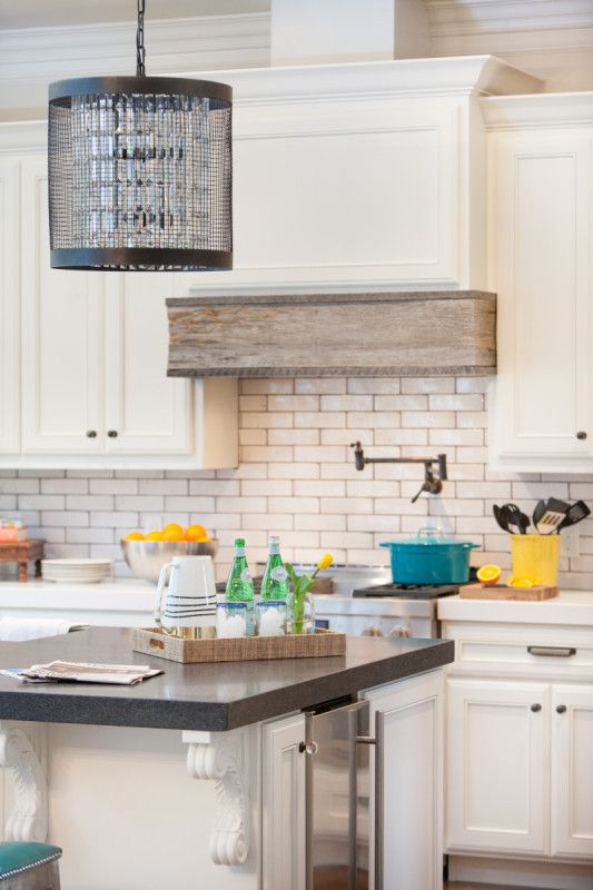 The tiled backsplash and wood covered hood add a rustic dimension to this contemporary kitchen