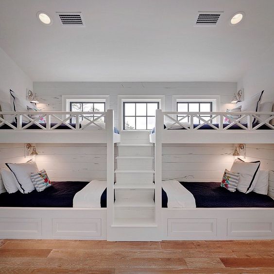 This bunk room was part of a much larger space. We designed and built these great bunks with four twin beds. I wanted it to be a space that would be comfortable for all ages and both boys and girls alike. A navy and white color scheme is both classic and crisp. The fun Otomi embroidered pillows add that fun pop of color on a sea blue cabana stripe.