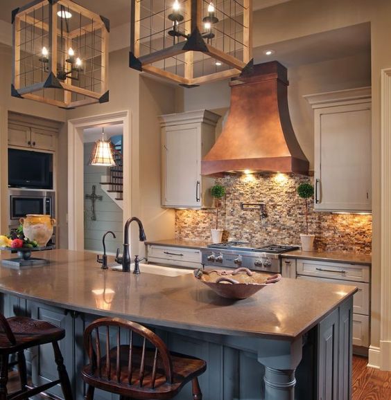 Warm and Welcoming Georgia Kitchen - The warmth of a custom, copper hood took center stage in creating a welcoming ambiance, and the cabinetry finish was equally important in creating the look.  A mix of finishes were selected to impart a 