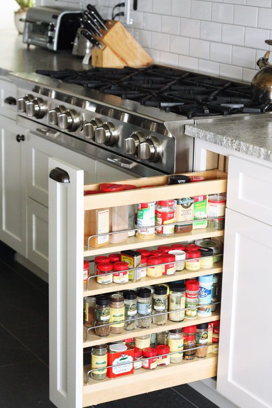 white kitchen stainless steel range spice cupboard