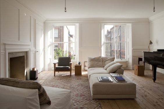 William Smalley flat in Bloomsbury, silver bottom light bulb pendants, wood floors with kilim, white paneled walls | Remodelista