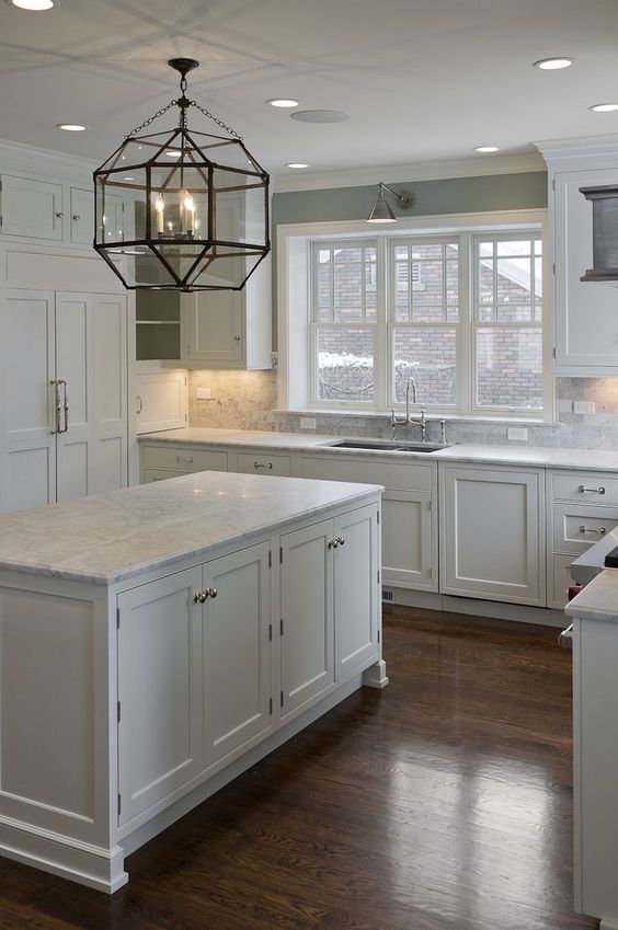 Dark floors,white cabinets, white granite, silver knobs and gray paint wall. Beautiful kitchen window