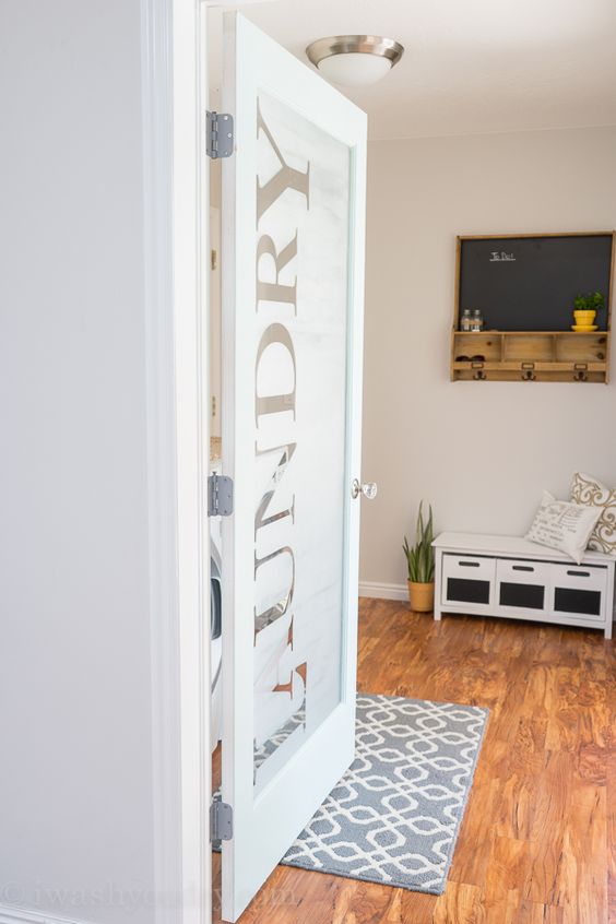 LOVE this Laundry Room door! She uses vinyl letters then frosted the glass for privacy, yet still lets in a lot of natural light. The rest of the kitchen reveal is just as awesome!