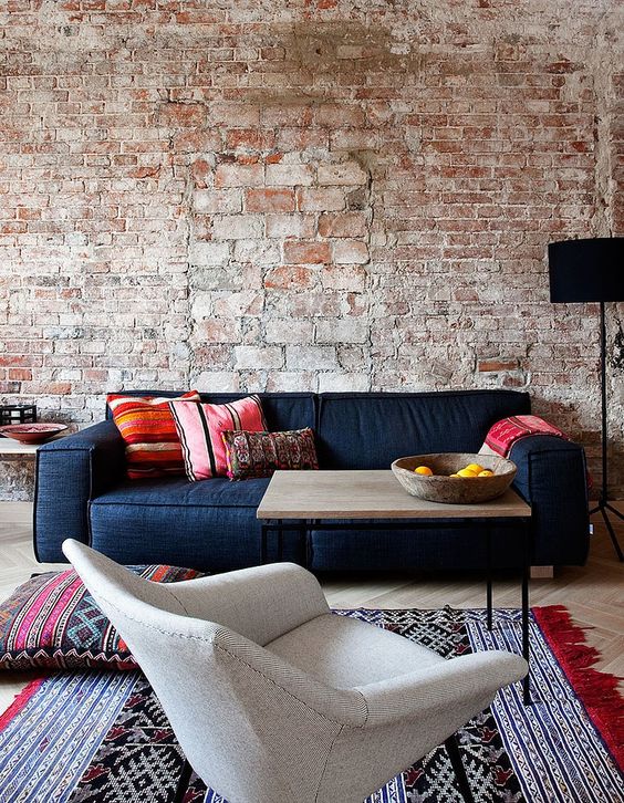 Modern rustic ethnic chic. brick wall + charcoal sofa + bright pillows #aphrochic