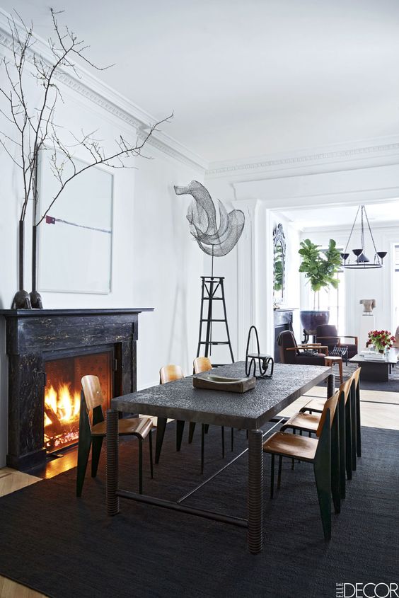 The dining table by Jerôme Abel Seguin is from Ralph Pucci, the vintage chairs are by Jean Prouvé, the photograph over the mantel is by Catherine Opie, the sculpture is by Elliott Hundley, and the vases on the mantel are by Rick Owens.