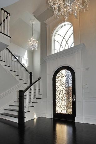 Traditional Entryway with Crown molding, High ceiling, Wainscotting, Monochromatic, Chandelier, French doors, Metal staircase