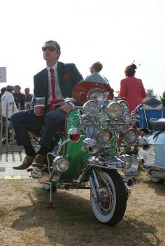 A Mod on his scooter having a pint.  Lookin' dapper as usual.
