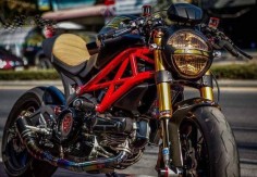 Black Ducati Monster with a custom seat, tinted headlights, clip-ons and Öhlins forks