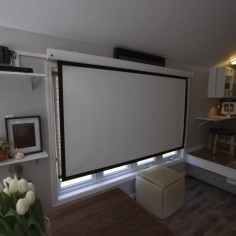 When you live tiny, you need to be extra crafty! Using a projector and retractable screen creates a movie theater look and feel in your tiny house, but keeps the space open and clean! Check out more tips and tricks for living tiny on FYI's #TinyHouseNation!