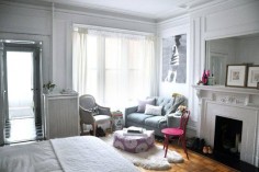 330 square foot studio apartment in New York City. manhattan, NYC, New York apartment, NY apt, fireplace mantel painted white, millwork, French chair, Louis chair, gray walls, purple patterned floor pouf, blue and white ceramic garden stool used as a side table, upholstered loveseat