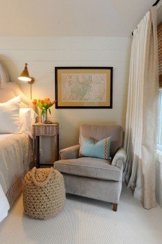 A cozy club chair adds warmth to a master bedroom. Chair on one side and small table.