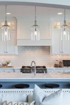 A trio of Corsica Pendants illuminate an extra long kitchen island topped with white quartz fitted ...
