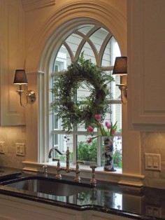 An unexpected warm touch by placing sconces on either side of the window over the kitchen sink