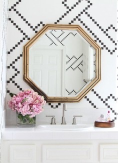 Bathroom with a gold mirror and black and white tiling