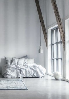 bed - white décor white walls white flooring -wooden beams - a bed built for cuddles - pendant lighting - minimalist