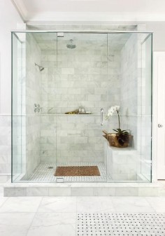 Chic master shower features ceiling and walls clad in marble brick tiles fitted with a marble shelf ledge finished with a marble pencil rail.