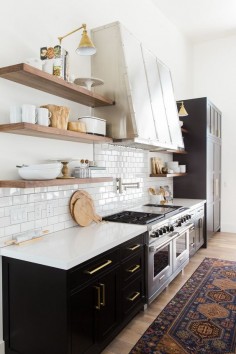 Dark cabinets, open shelving and brass details.