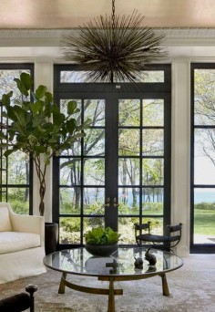 Gorgeous French doors and windows with black trim make a striking statement in this space. Kara Mann Design