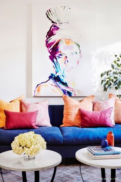 Living room with oversized, colorful artwork, a navy sofa, and colorful pillows