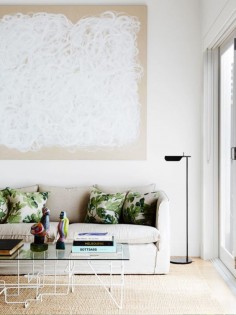 Living space with oversized artwork and glass coffee table
