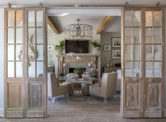 Mirrored antique doors were hung in a barn door hardware in the formal living room to bring character and patina. The pale pine vintage mirror door set also features a whitewashed finish.