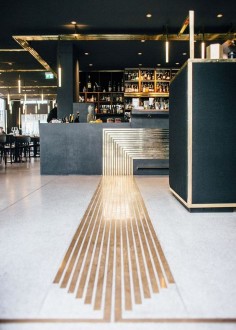 Modern bar design with metallic gold details on the floor and ceiling