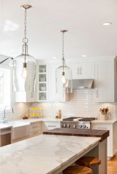 Modern Farmhouse Kitchen DesignThe light fixture above the island is the Glass Jug Lantern from Shades of Light – $179 each.