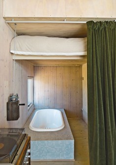Modern prefab vacation home in Washington guest bed that lifts to reveal a bathtub