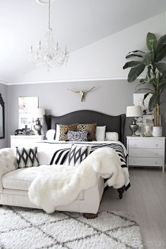 neutral bedroom with crystal chandelier, button tufted chaise, black and white accents and leather studded wingback bed - Cuckoo4Design